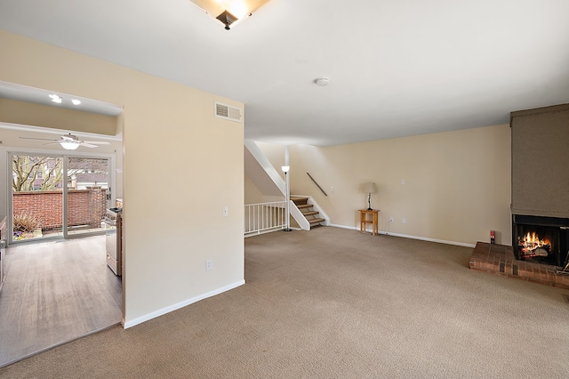 unfurnished living room featuring visible vents, stairs, baseboards, and a fireplace