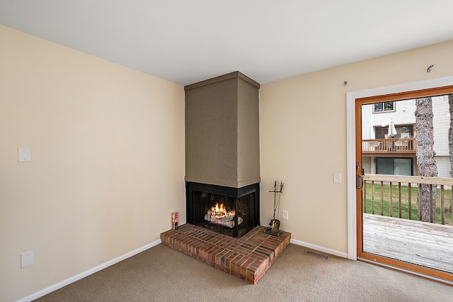 carpeted living room featuring a multi sided fireplace, baseboards, and visible vents