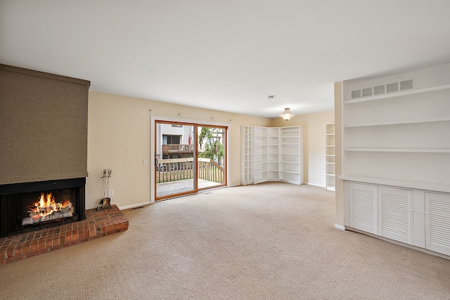 unfurnished living room featuring carpet floors, baseboards, a fireplace, and visible vents