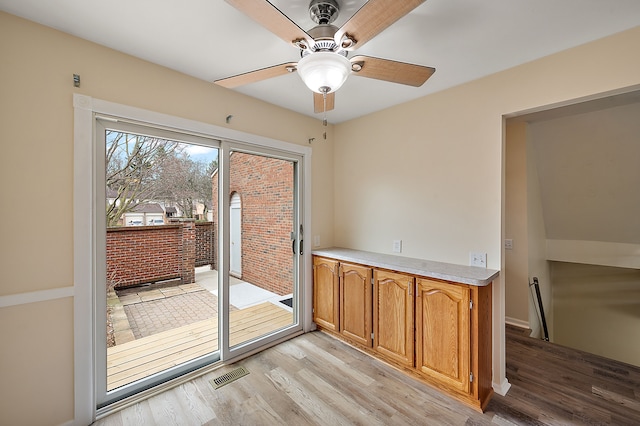 interior space with visible vents, a ceiling fan, baseboards, and light wood-type flooring