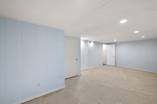 finished basement with recessed lighting and a decorative wall