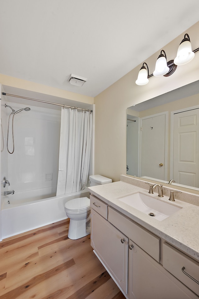 bathroom featuring vanity, visible vents, wood finished floors, toilet, and shower / bathtub combination with curtain