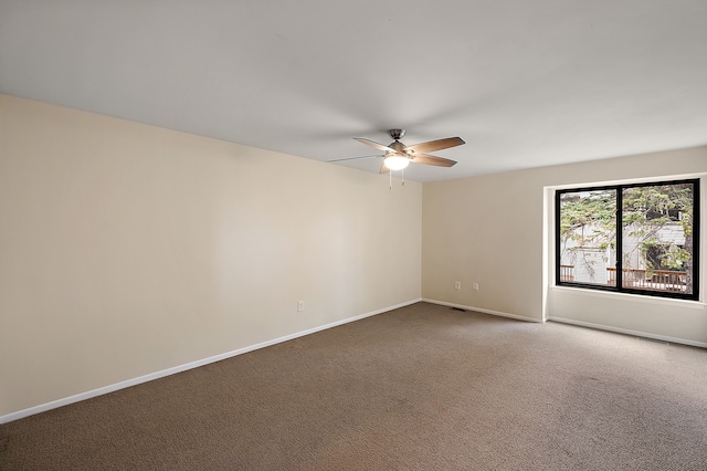 spare room featuring baseboards, ceiling fan, and carpet