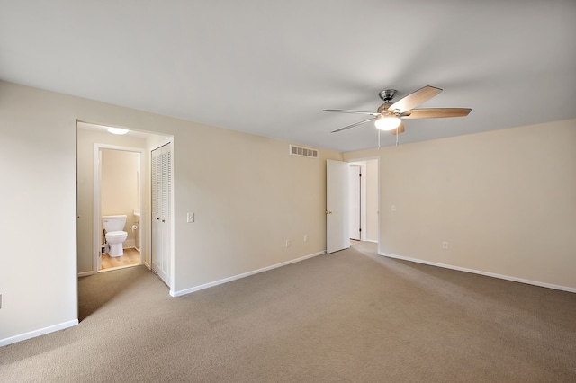 empty room featuring carpet flooring, a ceiling fan, baseboards, and visible vents