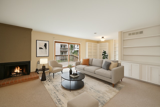 living area featuring visible vents, carpet flooring, and a large fireplace