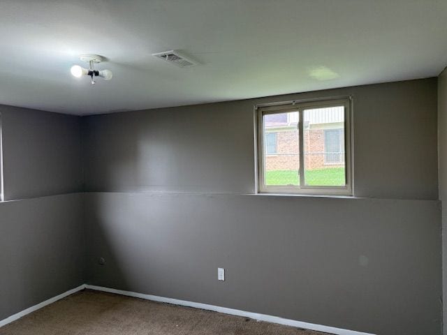 carpeted empty room featuring visible vents and baseboards