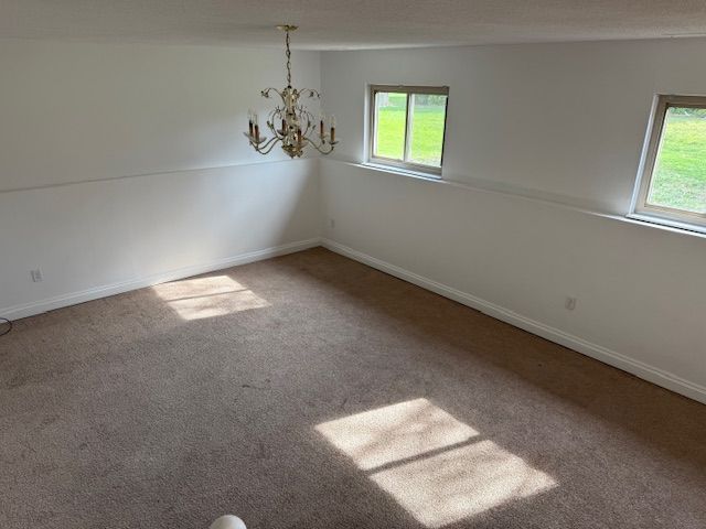 interior space with baseboards and a notable chandelier