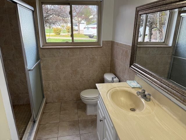 bathroom with vanity, tile patterned floors, a healthy amount of sunlight, and tile walls