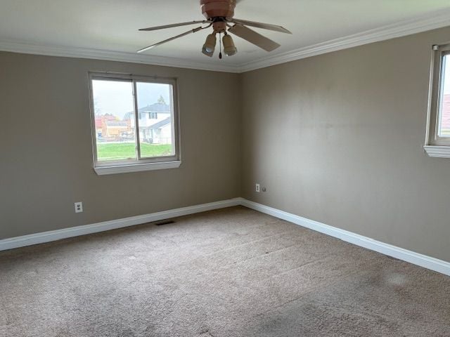unfurnished room with ceiling fan, ornamental molding, and baseboards