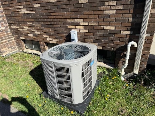 details featuring brick siding and cooling unit
