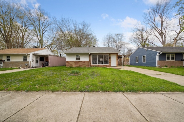 bungalow-style home featuring driveway, a front lawn, and brick siding