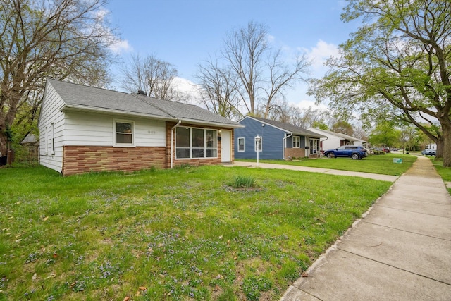 single story home featuring brick siding and a front yard