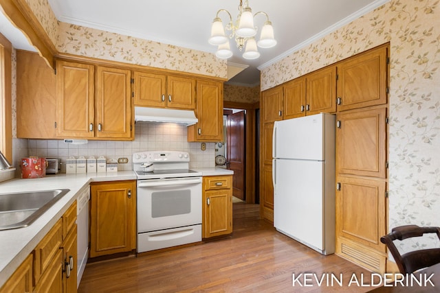 201 N Woodworth St, Corunna, MI 48817 - kitchen with white appliances, under cabinet range hood, wallpapered walls, wood finished floors, and light countertops