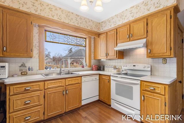 201 N Woodworth St, Corunna, MI 48817 - kitchen featuring white appliances, under cabinet range hood, wood finished floors, light countertops, and crown molding