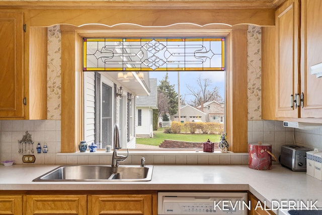 201 N Woodworth St, Corunna, MI 48817 - kitchen featuring dishwasher, backsplash, light countertops, wallpapered walls, and brown cabinetry