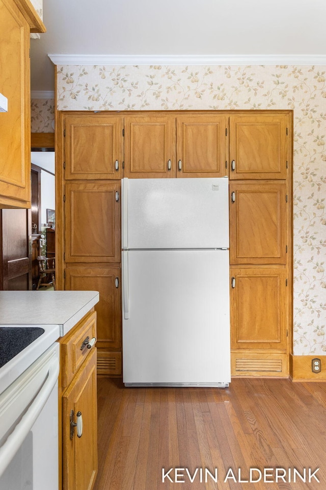 201 N Woodworth St, Corunna, MI 48817 - kitchen featuring freestanding refrigerator, wallpapered walls, dark wood-style floors, light countertops, and brown cabinets