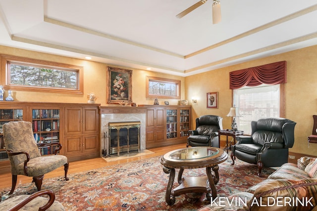 201 N Woodworth St, Corunna, MI 48817 - living area with light wood-type flooring, a high end fireplace, ceiling fan, and a raised ceiling