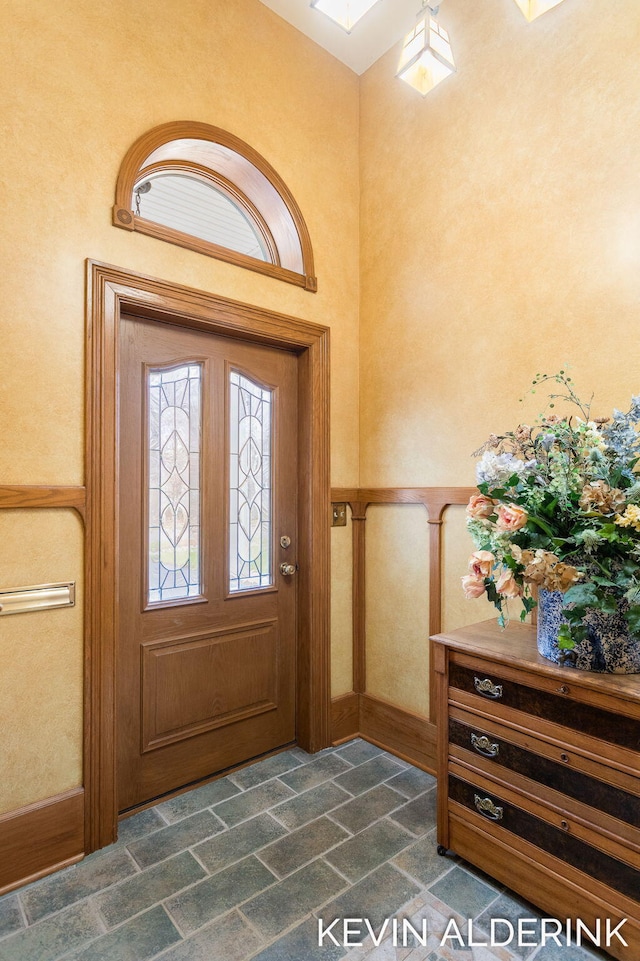 201 N Woodworth St, Corunna, MI 48817 - foyer with a wainscoted wall and dark stone finish flooring