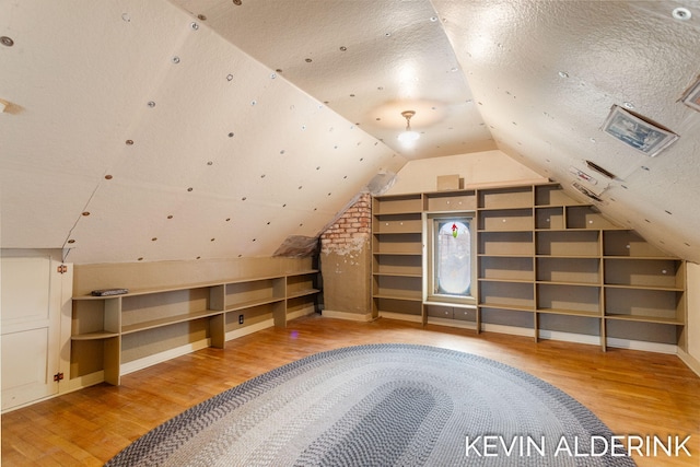 201 N Woodworth St, Corunna, MI 48817 - bonus room featuring wood finished floors, vaulted ceiling, and a textured ceiling