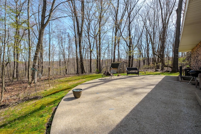 view of patio featuring a storage shed and an outbuilding