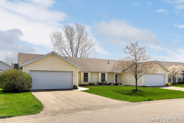 ranch-style house featuring a garage, a front lawn, a shingled roof, and concrete driveway
