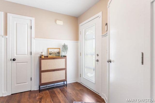entryway with dark wood-style flooring and wainscoting