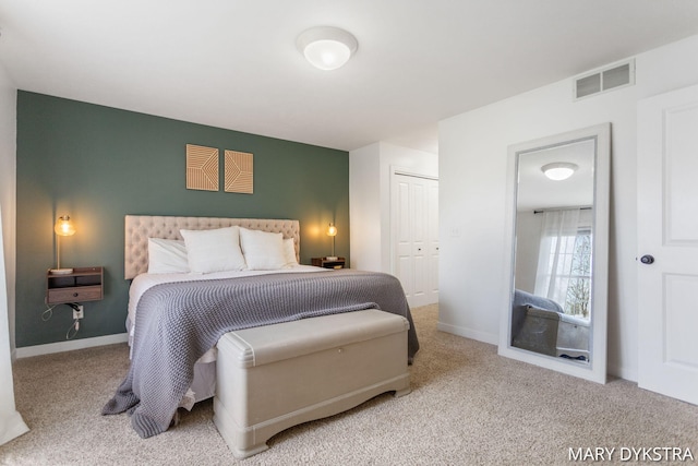 carpeted bedroom featuring baseboards, visible vents, and a closet