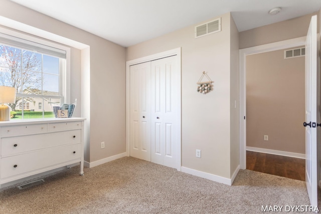 unfurnished bedroom featuring visible vents, carpet, and a closet