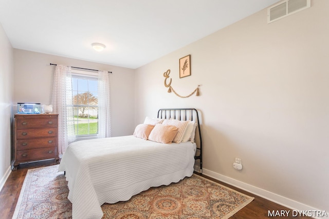 bedroom featuring baseboards, visible vents, and dark wood-type flooring