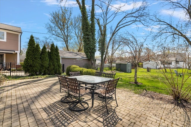 view of patio / terrace with an outdoor structure, fence, a storage shed, a residential view, and outdoor dining space