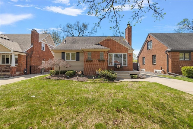 bungalow-style house with concrete driveway, brick siding, a gate, and a front yard