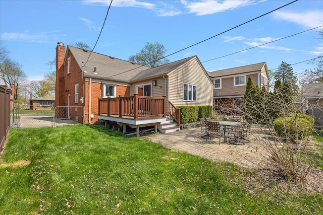 back of house featuring a chimney, a deck, a patio area, fence, and a yard