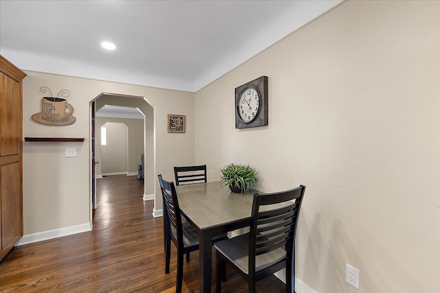 dining room featuring recessed lighting, arched walkways, baseboards, and dark wood-style floors