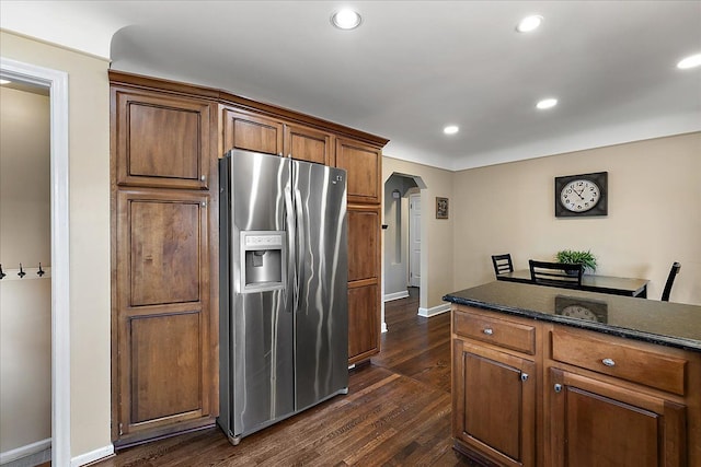 kitchen with stainless steel refrigerator with ice dispenser, arched walkways, dark wood finished floors, baseboards, and recessed lighting