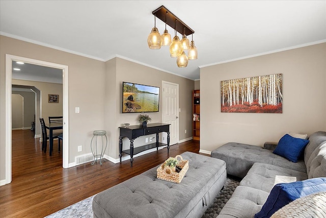 living room with an inviting chandelier, baseboards, ornamental molding, and wood finished floors
