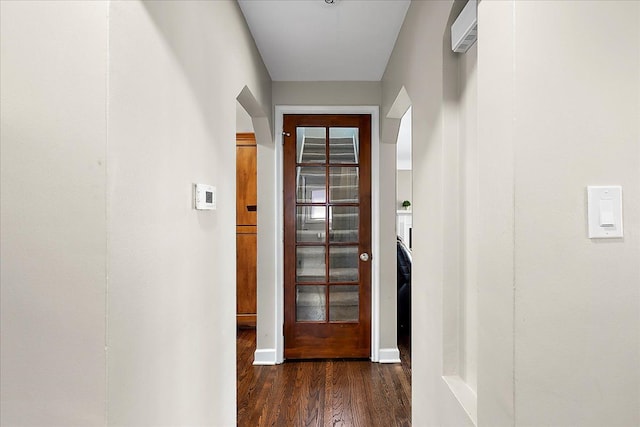 hallway featuring dark wood-style flooring and baseboards