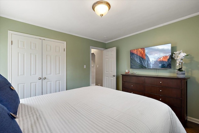 bedroom with crown molding, baseboards, dark wood-style flooring, and a closet