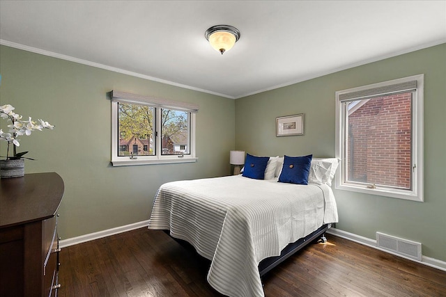 bedroom featuring visible vents, baseboards, and wood finished floors