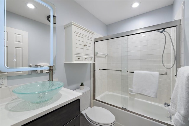 bathroom with toilet, recessed lighting, bath / shower combo with glass door, and vanity