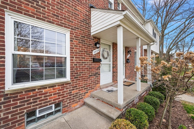 doorway to property featuring brick siding