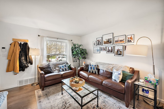 living room with baseboards, wood finished floors, and visible vents