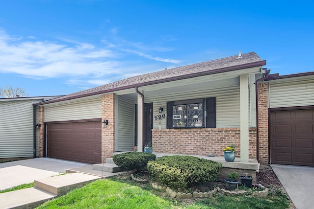 ranch-style house with brick siding, a garage, a porch, and concrete driveway