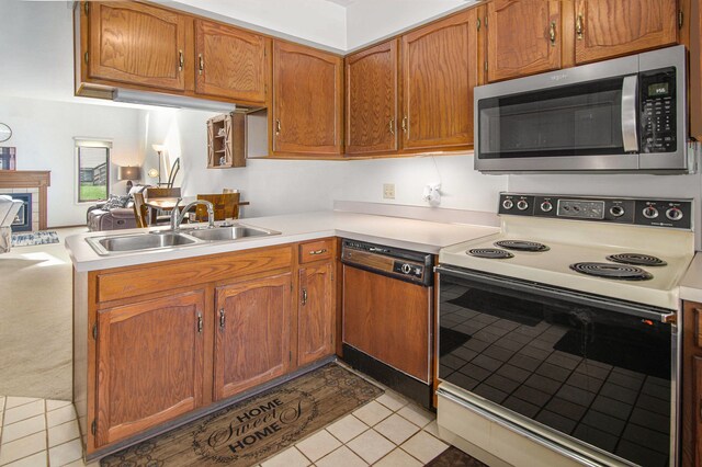 kitchen with a sink, light countertops, stainless steel microwave, paneled dishwasher, and white electric range oven