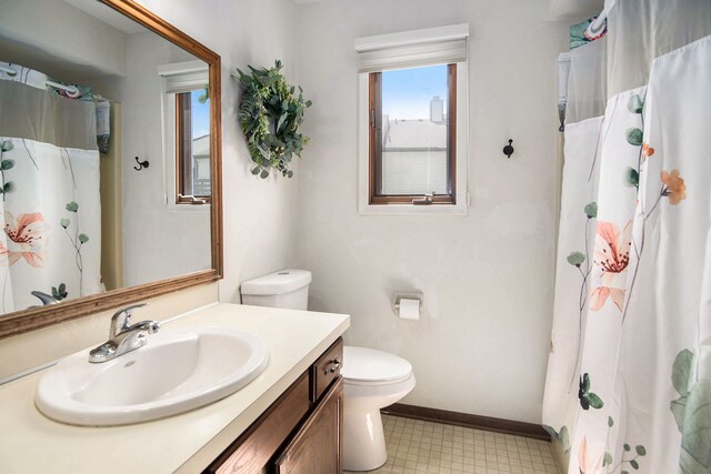 bathroom featuring vanity, toilet, tile patterned floors, baseboards, and curtained shower