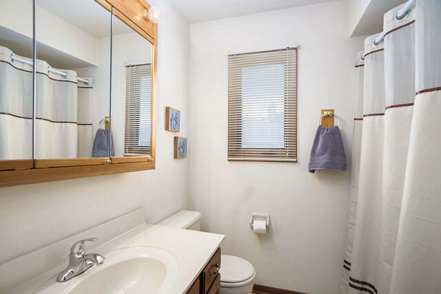 full bathroom featuring vanity, baseboards, curtained shower, and toilet