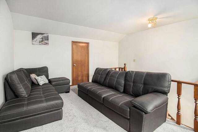 carpeted living room featuring vaulted ceiling