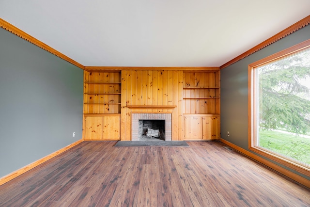 unfurnished living room with baseboards, ornamental molding, and a healthy amount of sunlight