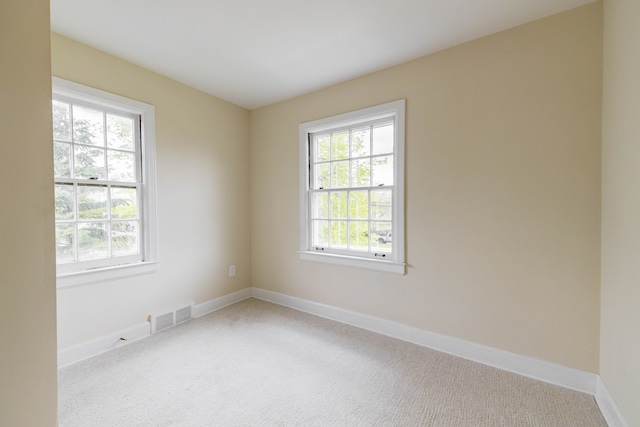 spare room featuring baseboards, carpet, and visible vents