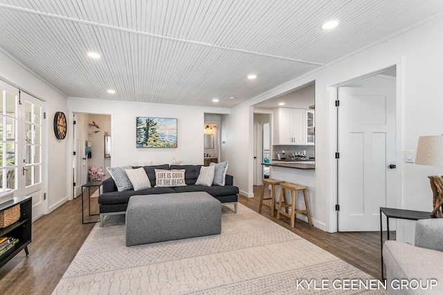 living area with dark wood finished floors, baseboards, ornamental molding, and recessed lighting