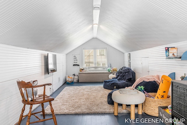interior space with hardwood / wood-style flooring, vaulted ceiling, and wood walls